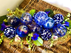 blue ornaments in wood bowl