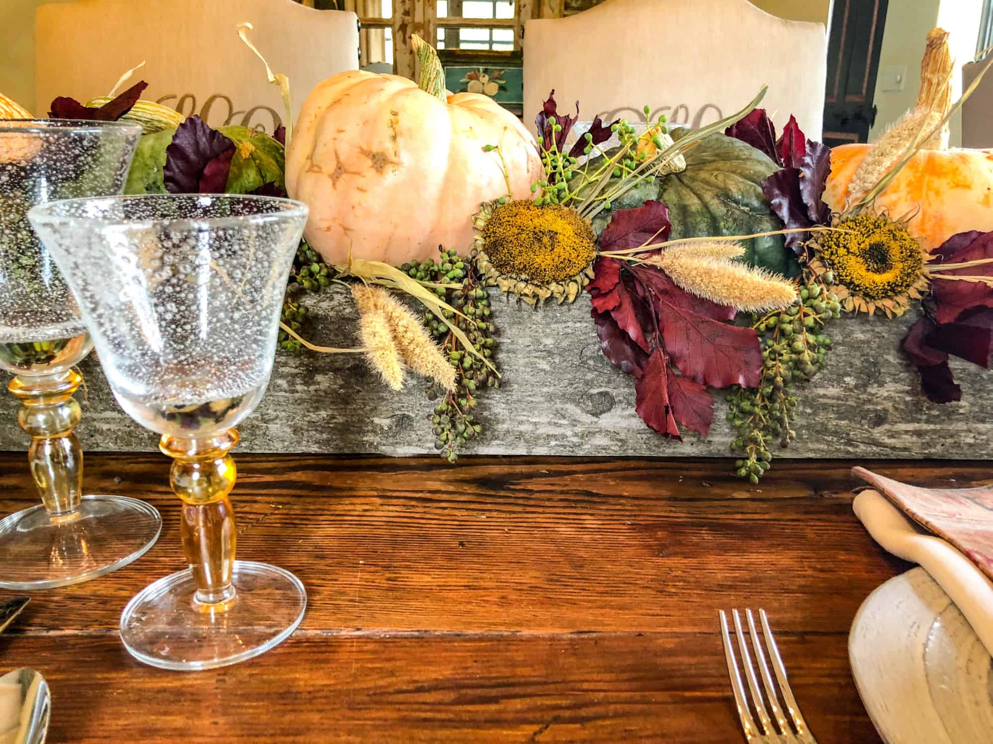 old fenceboard box filled with pumpkins and dried sunflower heads