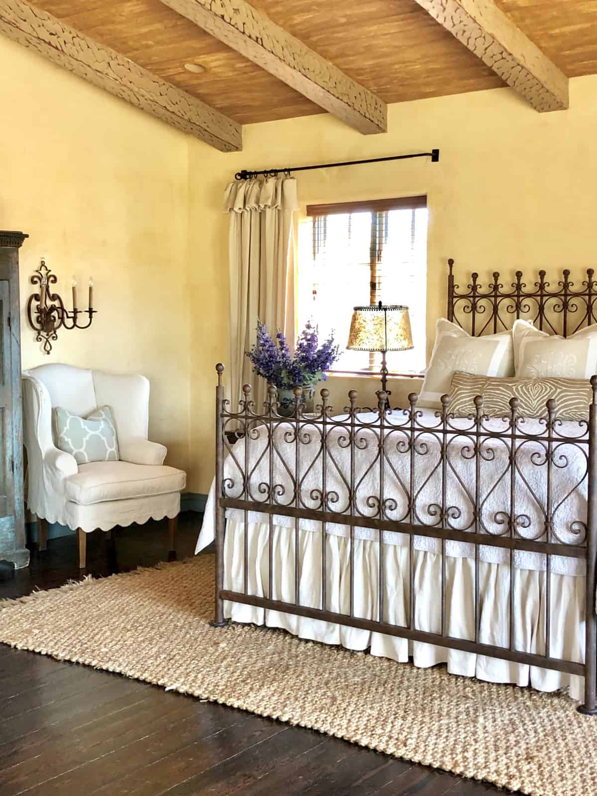 wrought iron bed with slipcovered chair