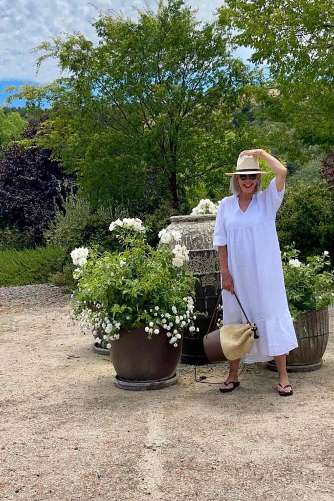 white midi dress hat and rattan backpack