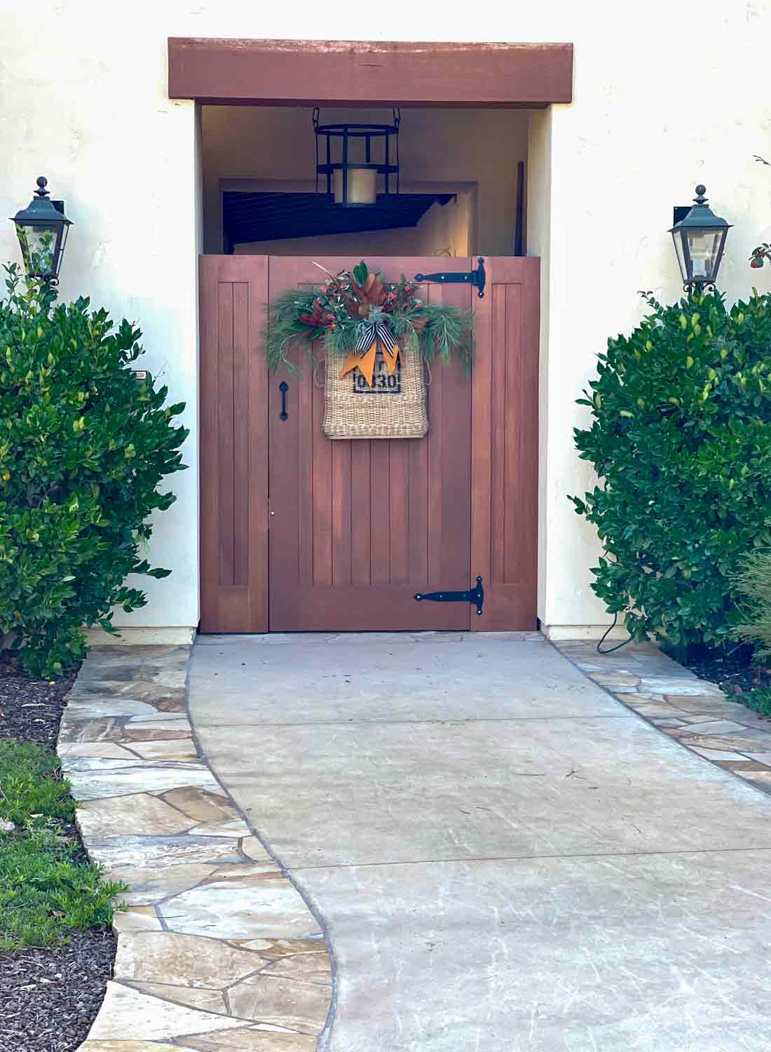 entry gate with vintage artillary baqsket filled with christmas greens