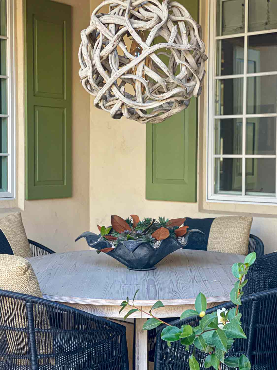 round table with vine light and iron bowl filled with succulents and magnolia leaves