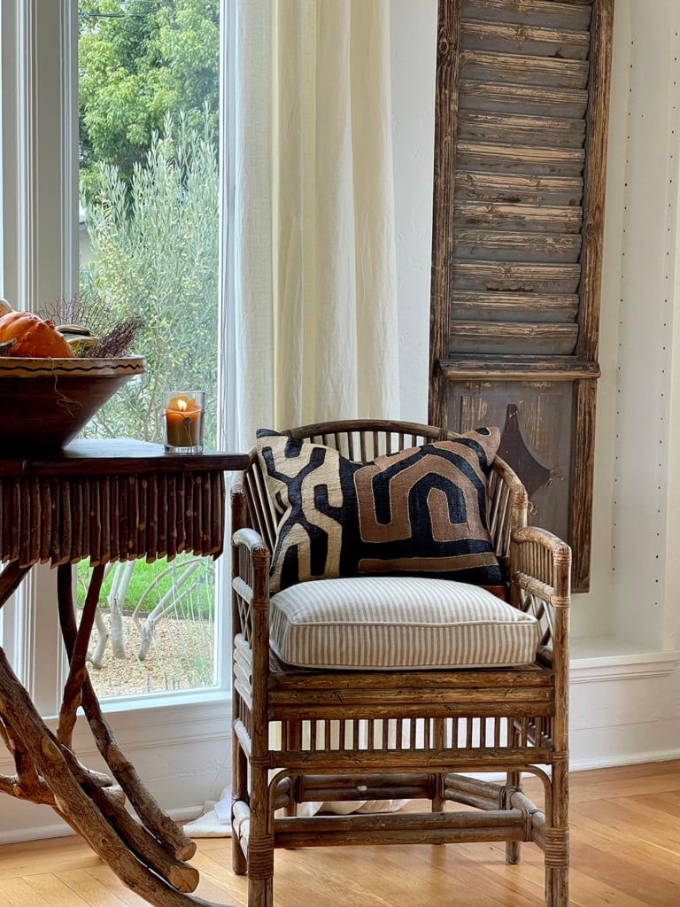 vintage shutter repurposed as wall art with twig table and chair