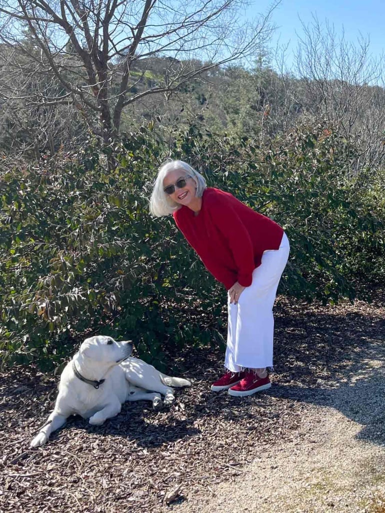 cindy hattersley and her pup in red cashmere and white jeans